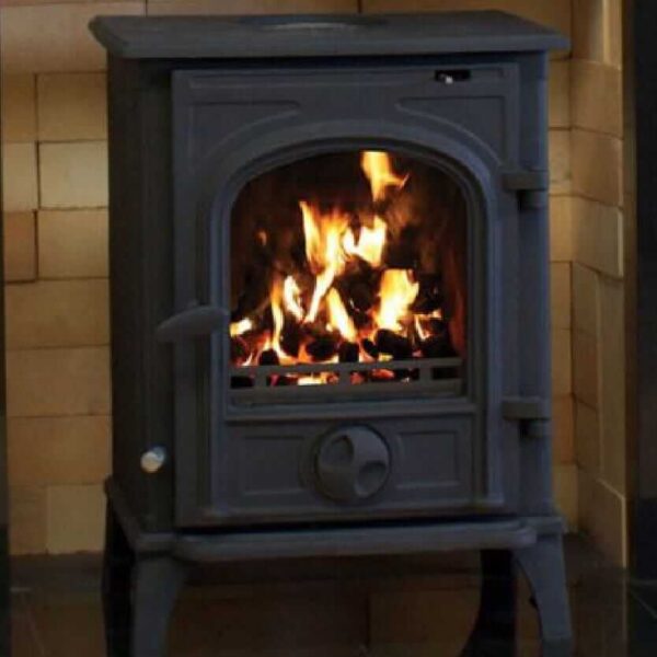 A Henley Trinity Erne Stove lit and sitting on a black granite fireplace surround