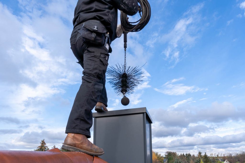 A man CLeaning a Chimney Using a Chimney Cleaning Kit