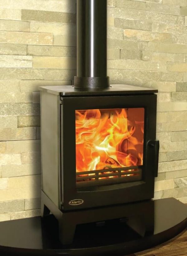 Atlantic Ocean Stove with large flames in the firebox, contrasting against a warm yellow tiled wall