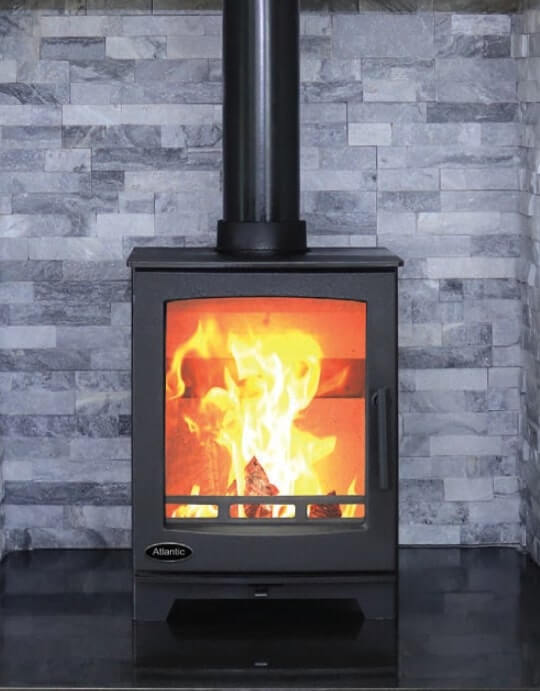 Atlantic Oyster 5kw Free Standing Stove sitting in a black slate tilled on a black straight edged shaped heart